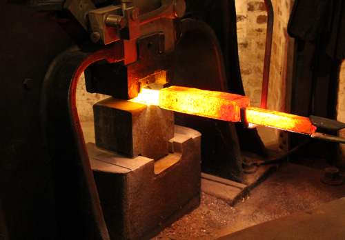 Image of red-hot metal piece being forged